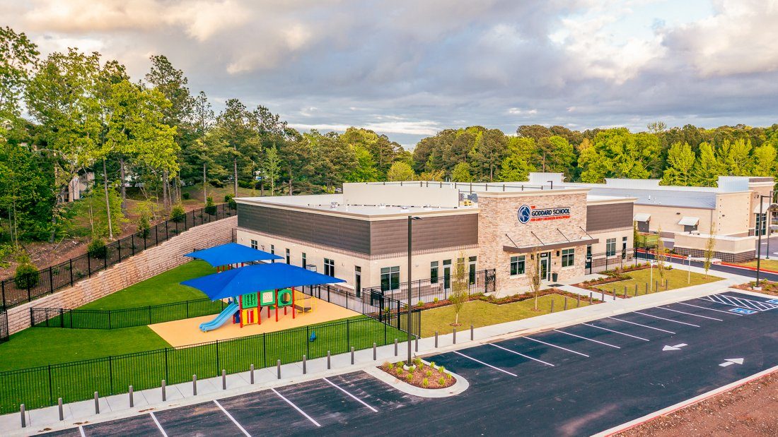 Aerial view of a completed Goddard School building with a fenced playground